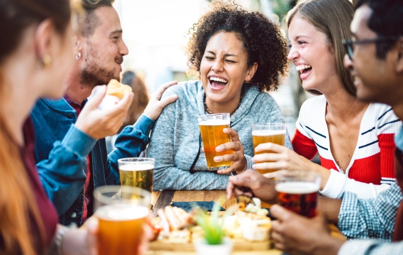 A group of friends laugh over beer at one of the Estes Park breweries.