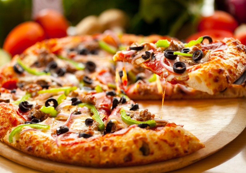 Best Pizza in Estes Park: A pizza-lover pulls a slice from a supreme pizza in Estes Park.