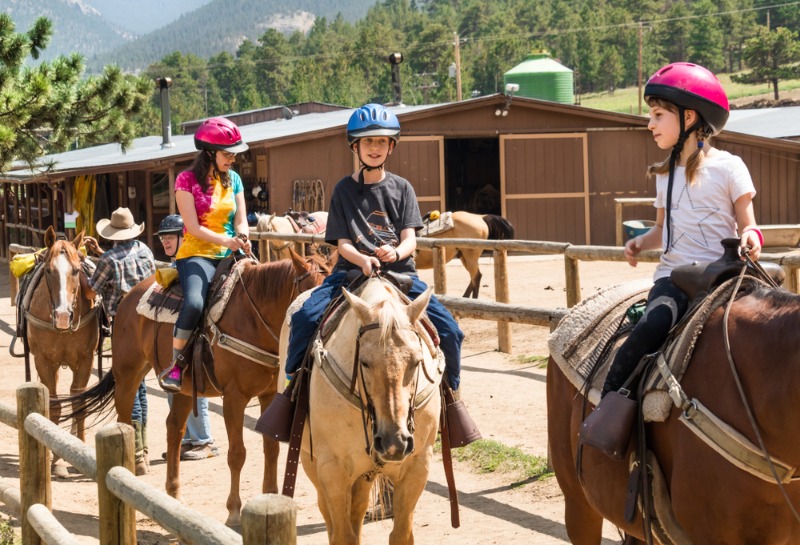 Horseback Riding Estes Park: Two youngsters and their mother prepare for a horseback riding adventure in Estes Park.